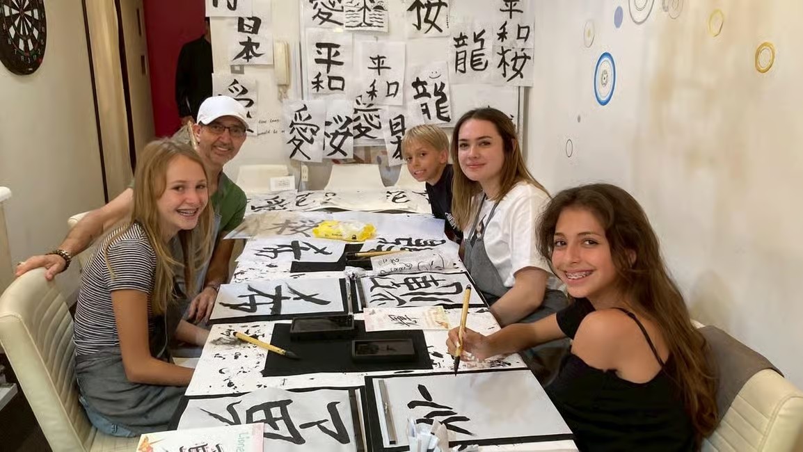 Inside our Hiroshima workshop, with guests around the calligraphy table